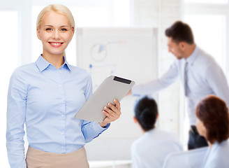 Image showing smiling woman looking at tablet pc computer