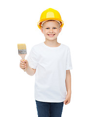 Image showing smiling little boy in helmet with paint brush