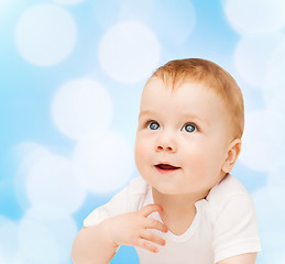 Image showing smiling baby lying on floor and looking up