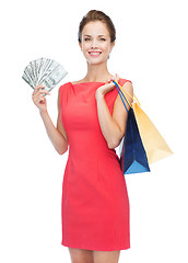 Image showing smiling woman in red dress with shopping bags