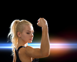 Image showing close up of athletic woman flexing her biceps