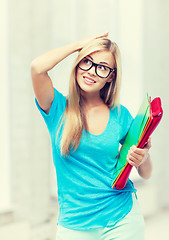 Image showing stressed student with folders in campus