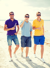 Image showing male friends on the beach with bottles of drink