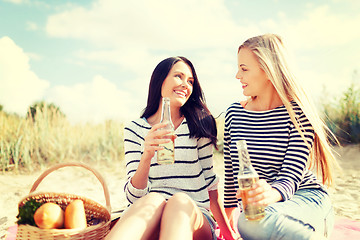 Image showing girlfriends with bottles of beer on the beach