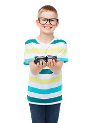 Image showing smiling boy in eyeglasses holding spectacles