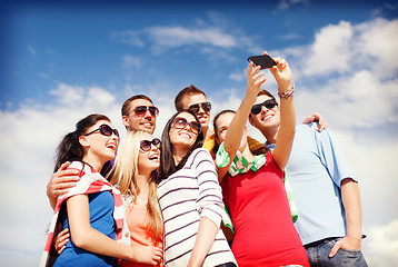 Image showing group of friends taking picture with smartphone