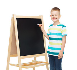 Image showing happy little boy with blackboard and chalk