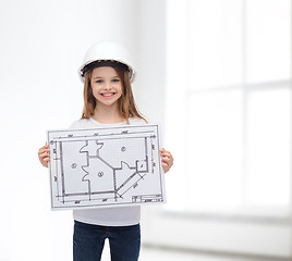 Image showing smiling little girl in helmet showing blueprint