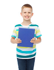 Image showing smiling little student boy with blue book