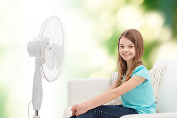 Image showing smiling little girl with big fan at home