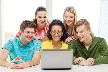 Image showing smiling students looking at laptop at school