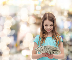 Image showing smiling little girl looking at dollar cash money