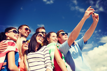 Image showing group of friends taking picture with smartphone