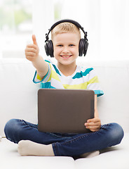 Image showing little boy with tablet pc and headphones at home