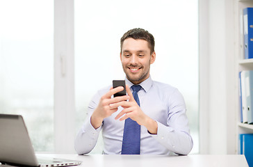 Image showing businessman with laptop and smartphone at office