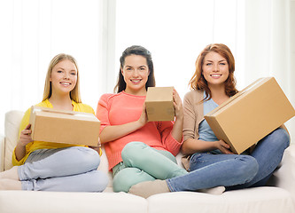 Image showing smiling teenage girls with cardboard boxes at home