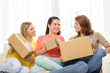 Image showing smiling teenage girls with cardboard boxes at home