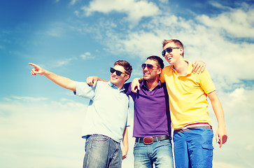 Image showing group of male friends walking on the beach