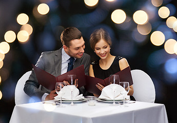 Image showing smiling couple with menus at restaurant