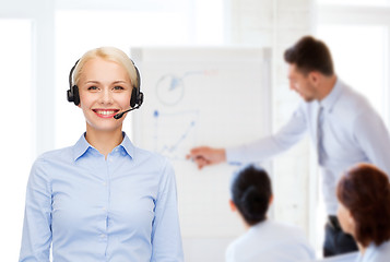 Image showing friendly female helpline operator with headphones