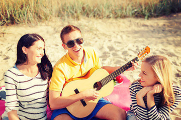 Image showing group of friends with guitar having fun on beach