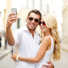 Image showing smiling couple taking selfie with smartphone