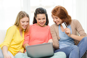 Image showing smiling teenage girls with laptop and credit card