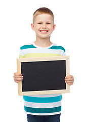 Image showing smiling little boy holding blank black chalkboard