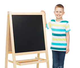 Image showing happy little boy with blank blackboard