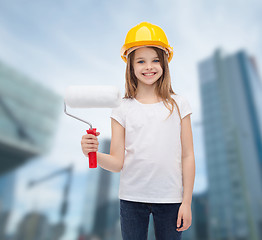 Image showing smiling little girl in helmet with paint roller