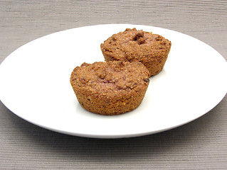 Image showing Two raspberry muffins on a white plate of chinaware