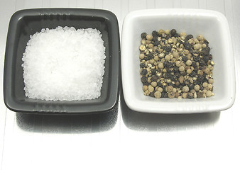 Image showing Bowls of chinaware with salt and pepper on reflecting matting