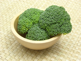 Image showing Wooden bowl with broccoli on rattan underlay