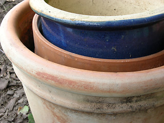 Image showing Three stacked brown and blue plant pots