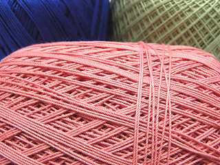 Image showing Three balls of wool  in blue, pink and green in a close-up view