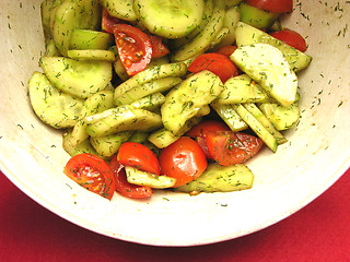 Image showing Cucumbers and tomatoes with salat dressing in a bowl of ceramics