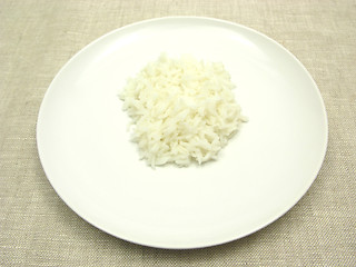 Image showing Cooked rice on a white plate and beige background