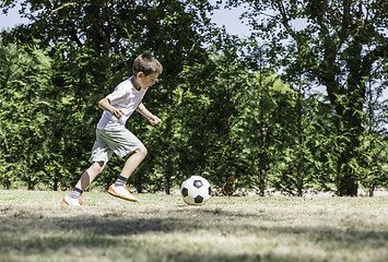 Image showing Child playing football in a stadium