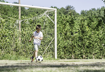 Image showing Child playing football in a stadium