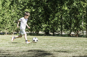 Image showing Child playing football in a stadium