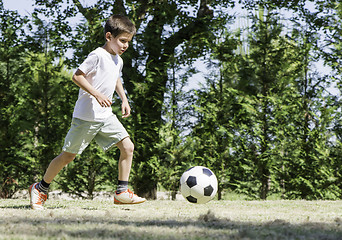 Image showing Child playing football in a stadium