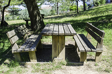 Image showing Wooden benches and a table in the woods