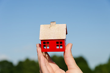 Image showing hand hold house miniature on blue sky background 