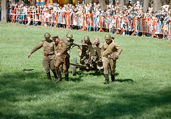 Image showing Soldiers wheel artillery cannon