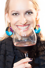 Image showing Toasting with a glass of red wine.