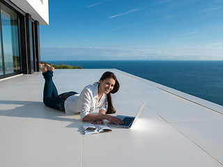 Image showing relaxed young woman at home working on laptop