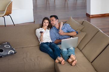 Image showing relaxed young couple working on laptop computer at home