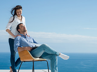 Image showing relaxed young couple working on laptop computer at home