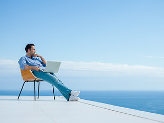 Image showing relaxed young man at home on balcony