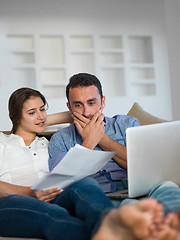 Image showing relaxed young couple working on laptop computer at home